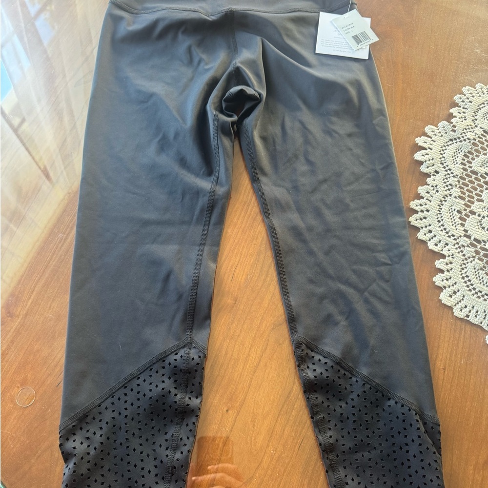 Beyond Yoga woman’s Black Leggings with Laser-Cut Hem Panels